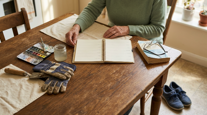 Retirement hobby week represented by walking shoes, art supplies, gardening gloves, and reading.